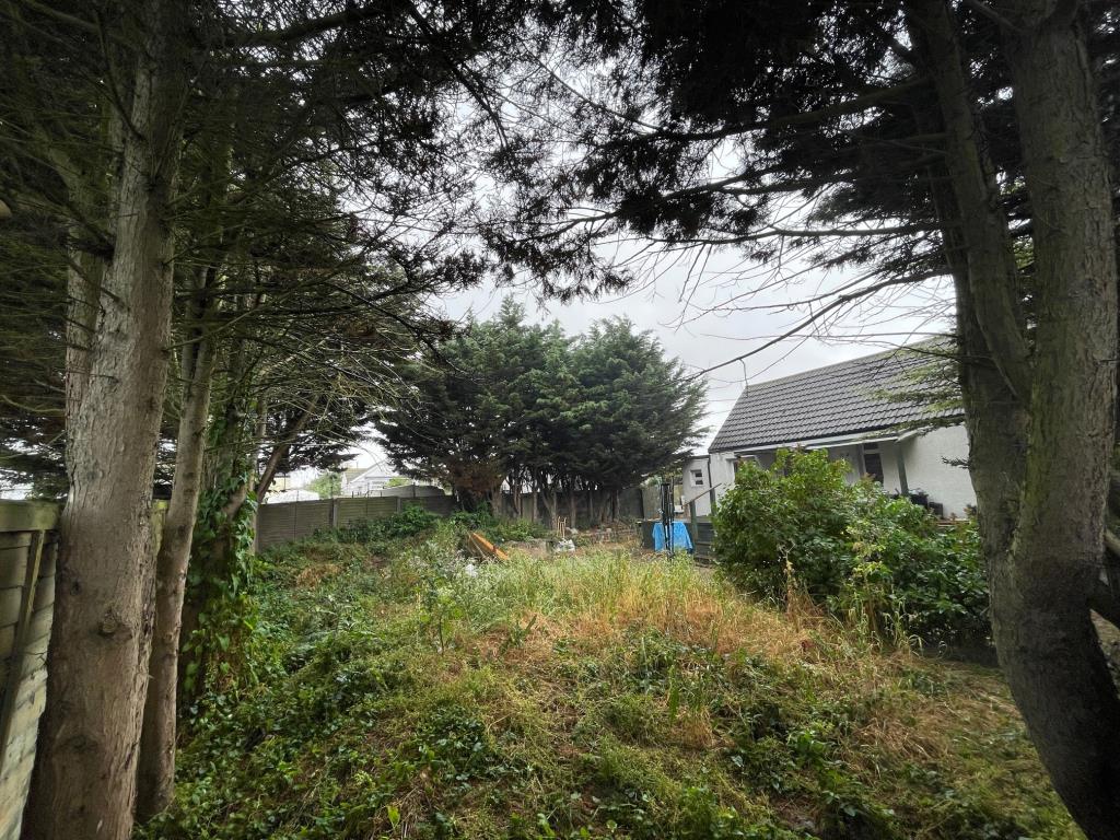 Lot: 30 - VACANT TWO-BEDROOM CHALET ON DOUBLE PLOT - view of garden and chalet looking over the fence